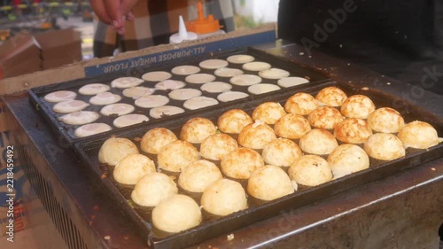 the process of cooking takoyaki using traditional molds, the most popular and delicious Japanese street food.