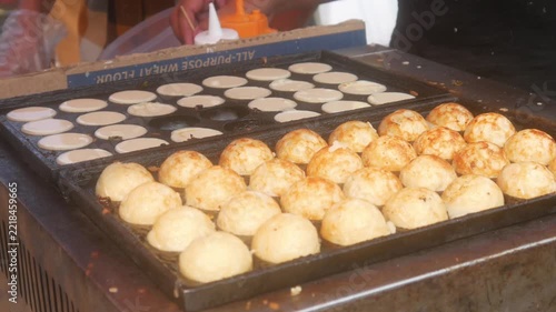 the process of cooking takoyaki using traditional molds, the most popular and delicious Japanese street food.