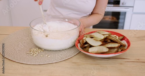 Baker occupation. Mixing dough. Female hand stirring flour batter at home kitchen modern workplace preparing dessert with sliced pear.