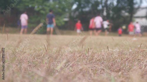 blur of a group of children playing soccer in an open field with a low angle view