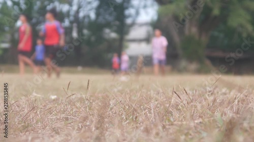 blur of a group of children playing soccer in an open field with a low angle view
