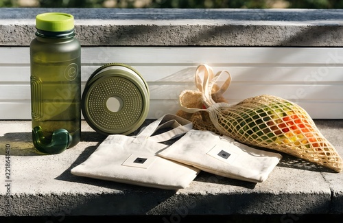 Sustainable lifestyle collection featuring a reusable green bottle mesh produce bag and cotton