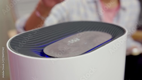 Close-up, hand of woman turns on PM 2.5 air purifier or adjust at home
