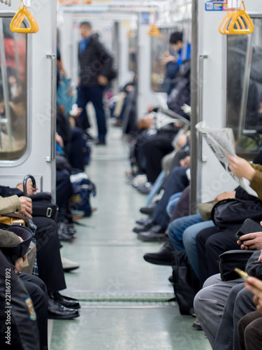冬の日本の都市の通勤電車内の人々の姿