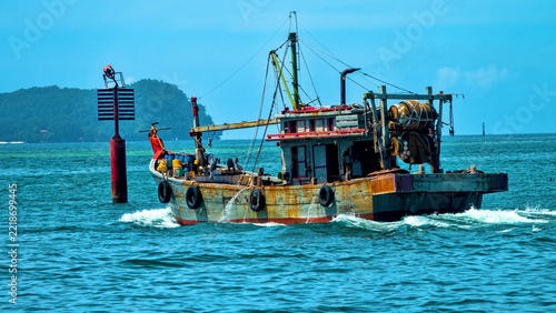An old wooden fishing schooner goes out to catch fish and shrimp. Malaysia, South China Sea.