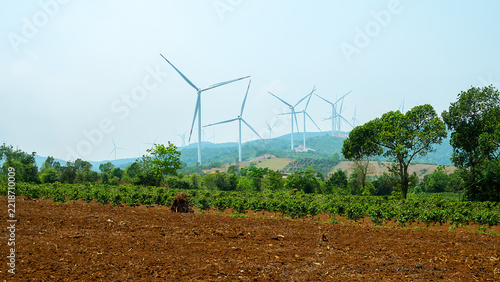 Vietnam's modern energy industry - traditional electric lines from a hydroelectric power plant and wind turbines on mountain slopes