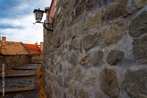 Obraz na plátně Old Street Lamp on Stone Wall along Cobblestone Steps in Historic Town