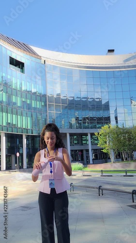 Businesswoman drinking water outside modern office building