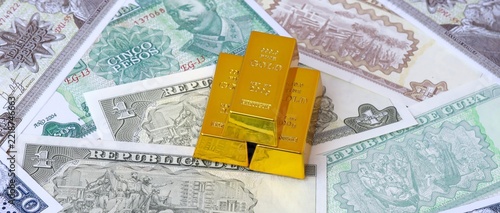 Fotografie Cuban peso money bills and gold bullion bars