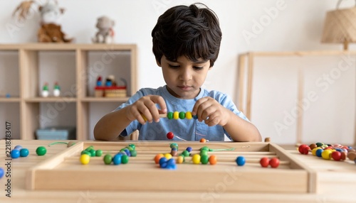 Child Practicing Fine Motor Skills with Colorful Beads