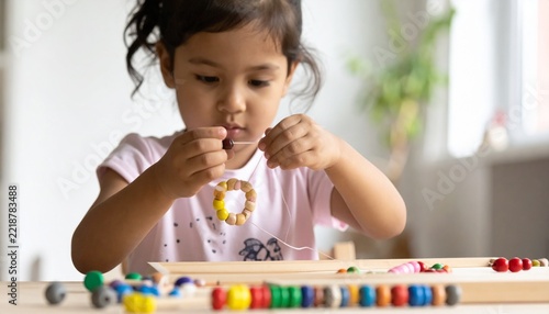 Child Practicing Fine Motor Skills with Colorful Beads