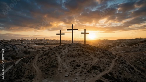 Three wooden crosses on Calvary hill overlooking Jerusalem at sunset