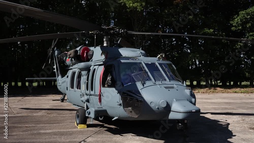 Military Sikorsky UH 60 Black Hawk helicopter parked on a concrete airfield with its rotor blades stationary showcasing a powerful utility aircraft used for tactical missions
