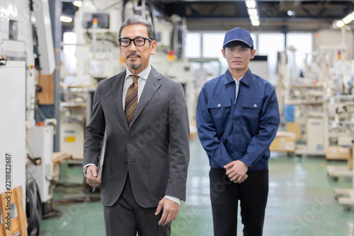 外国人労働者を日本の製造工場へ紹介する人材仲介業者の日本人男性と外国人男性作業員