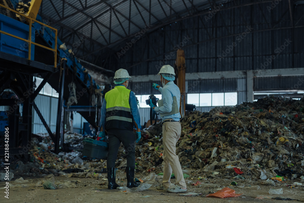Fototapeta premium environmental engineers inspecting organic waste pile in waste to energy power plant.