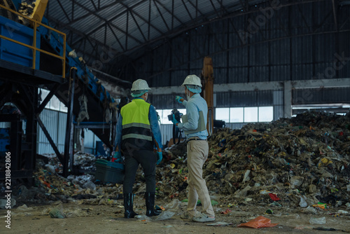 environmental engineers inspecting organic waste pile in waste to energy power plant.