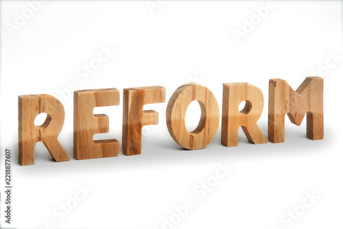 Obraz na plátně Wort Reform aus Holzbuchstaben vor weißem Hintergrund – Symbol für Veränderung