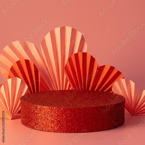 Glittery red circular pedestal platform for product display presentation features pleated paper fan decorations arranged in creative semicircular shapes perfect for seasonal celebrations and