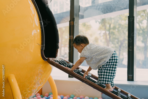 An Asian girl is climbing and playing at the amusement park; Asian families are traveling and relaxing