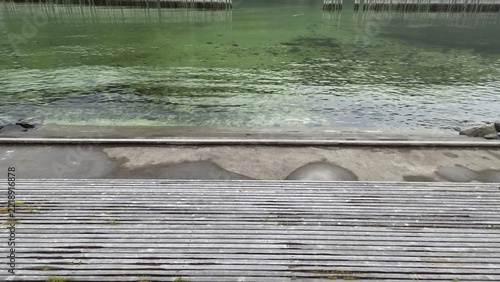 Clear water near wooden platform at the edge of a lake in the afternoon
