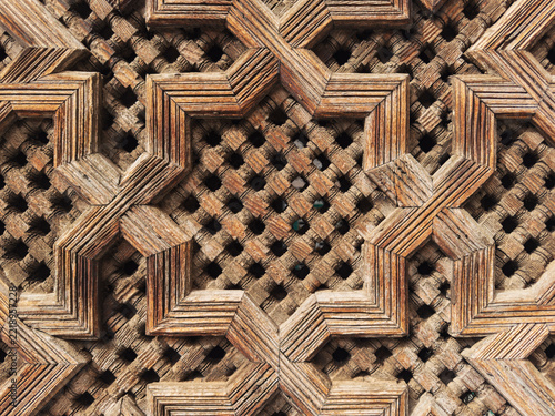Lattice Woodwork, geometric carvings and patterns in a fretwork screen in the historic Medresa El Bouanania.