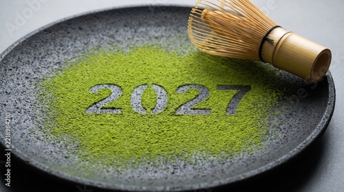 Green matcha powder with 2027 year date written on a dark ceramic
