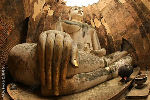 Fotografie Ancient giant sculpture of a sitting Buddha (Phra Achana) in the ruins of the Buddhist temple at Wat Si Chum
