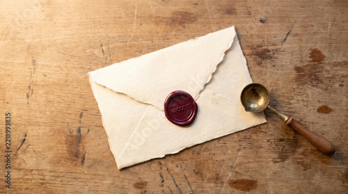 Vintage linen envelope with red wax seal and metal melting spoon on