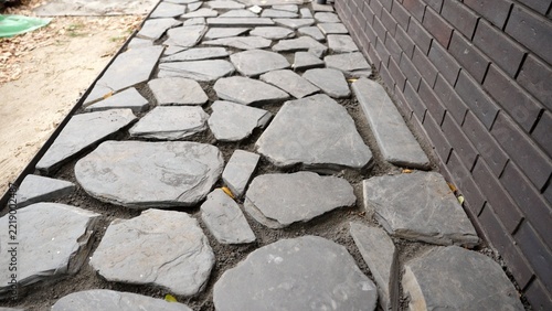 Laying a slate flagstone garden path and filling gaps with crushed stone