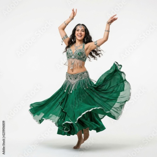 Happy woman dancing in a beautiful green belly dance costume with silver accessories isolated on white background