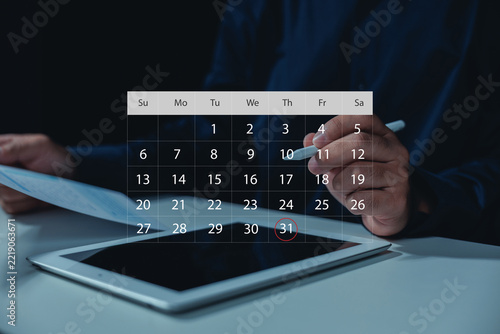 Business professional using a digital calendar on tablet with stylus, showing schedule planning, appointment management, monthly deadlines, time organization, productivity, and business workflow.