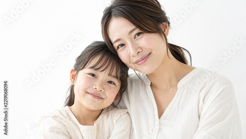 寄り添って優しく微笑む日本人の母親と娘、親子の愛情と絆を表現したポートレート