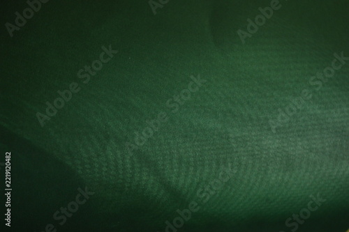 Deep forest green fabric texture with subtle woven pattern and soft natural light highlights
