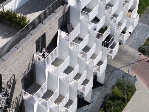 Aerial view of modern apartment building with staggered white balconies and brick facade, Krakow, Lesser Poland Voivode, Poland.