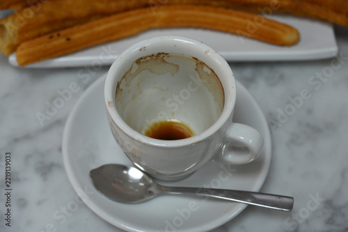 espresso coffee cup with traditional churros, white espresso coffee cup with spoon and freshly prepared traditional churros served on a plate, classic sweet breakfast or cafe snack