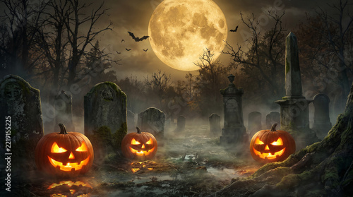 Jack o lantern pumpkins gleam warmly through carved grimaces amidst a foggy midnight graveyard.
