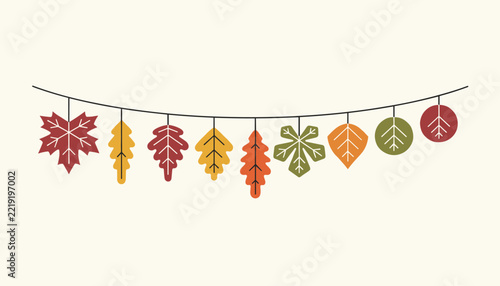 String of colorful autumn leaves in various shapes and fall colors hanging as a bunting decoration against a plain cream background.