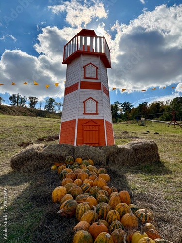 Decorative lighthouse and pumpkins at autumn farm festival