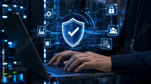 Person working on laptop with cybersecurity shield protecting data