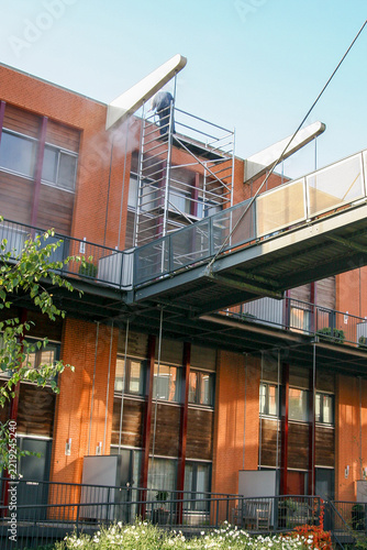 Professional Cleaner Using a Pressure Washer on a Building Facade