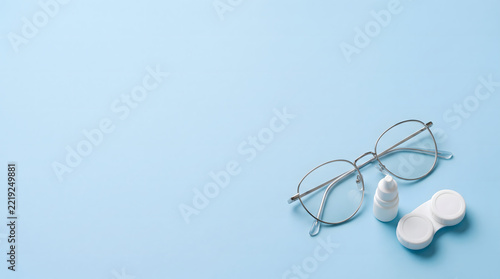 Eyeglasses with contact lens case and eye drops bottle isolated on