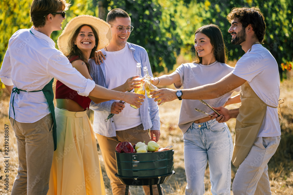 Fototapeta premium Friends celebrating together around an outdoor food station in a vineyard