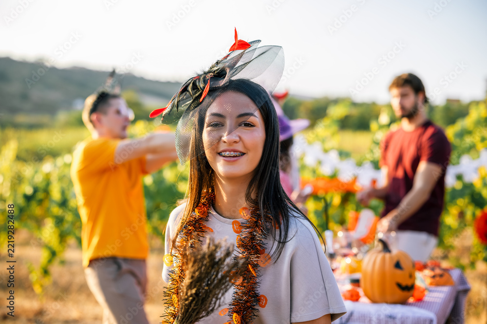 Fototapeta premium Woman wearing a creative Halloween headpiece during a vineyard celebration
