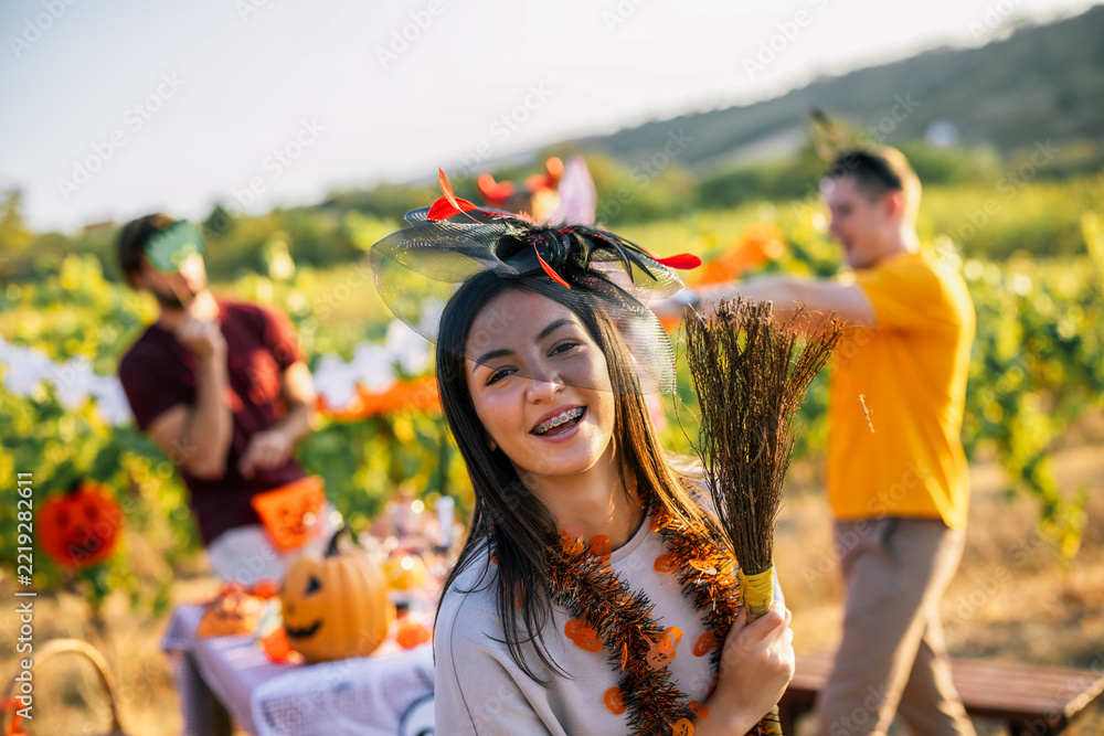 Naklejka premium Smiling woman in Halloween costume celebrating outdoors with friends