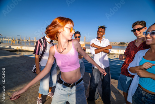 Group of diverse gen z friends dancing outdoors enjoying summer
