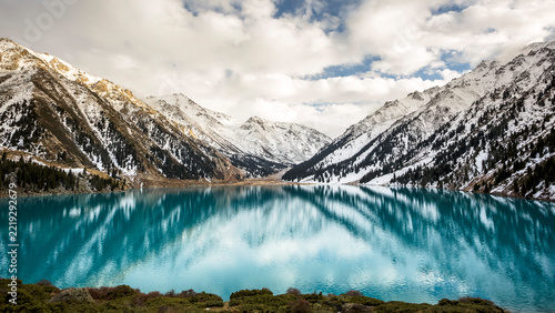 Scenic view of Big Almaty Lake with striking turquoise water surrounded by snow-dusted mountains near Almaty, Kazakhstan, a spectacular destination for mountain travel and nature tourism in Central As