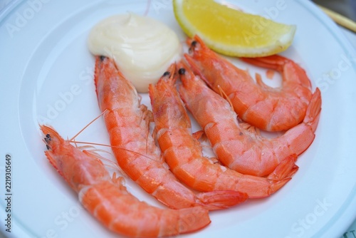 Plate of shell-on shrimp with mayonnaise and lemon