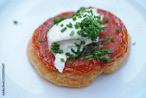 View of a tomato tarte Tatin upside down pie with cheese and chives