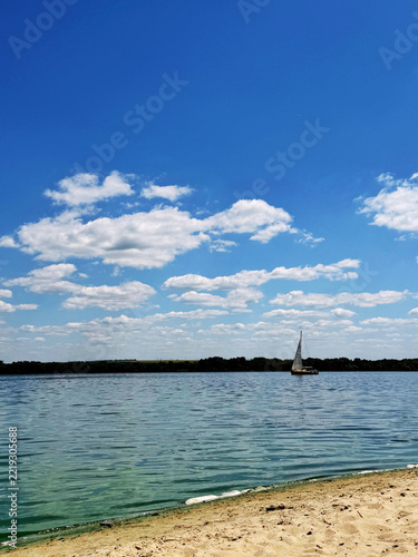A view on a Dnipro river with a small yacht on a bright summer day