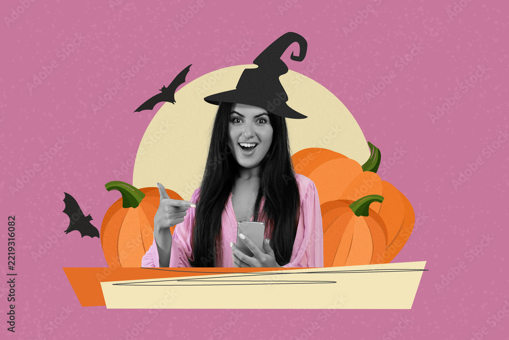 Fototapeta premium Smiling Young Woman With Long Dark Hair Wearing Witch Hat Holding Smartphone, Pointing At Screen In Celebration Of Halloween, October Festivities In Vibrant Purple Background. Fun Concept.